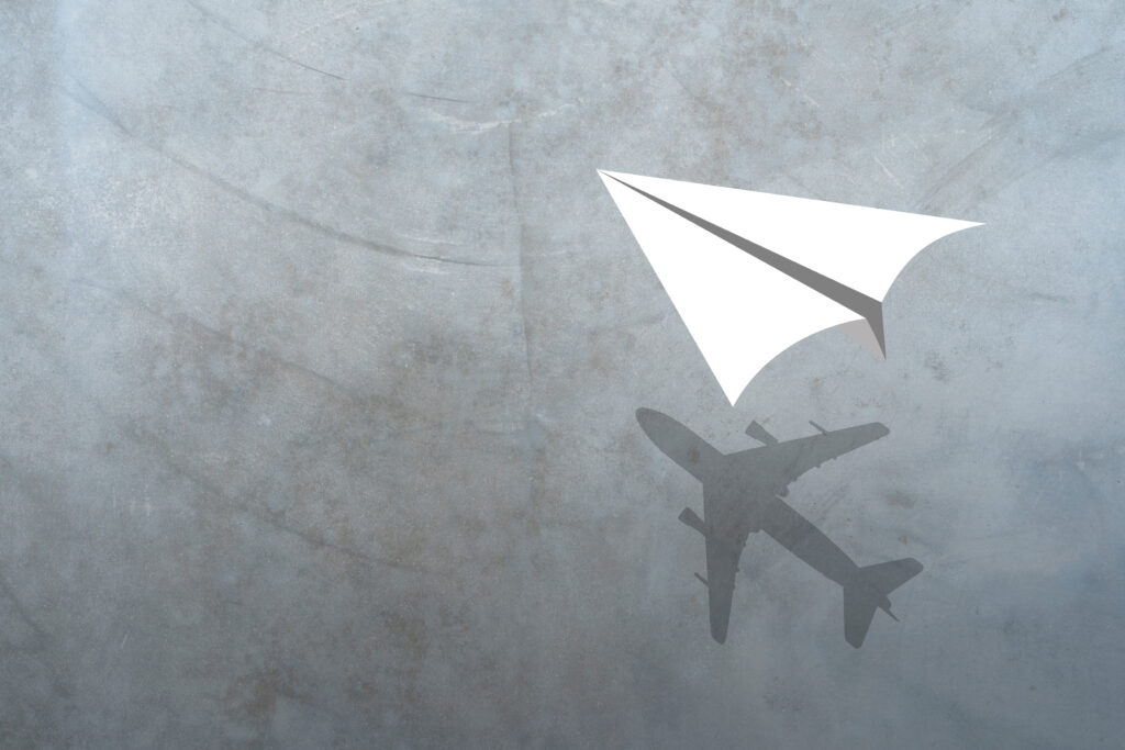 Papierflieger und Flugzeug