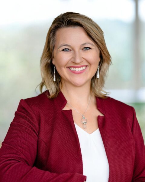 Portrait von Birgit Nieschalk mit weißem Shirt und rotem Jacket